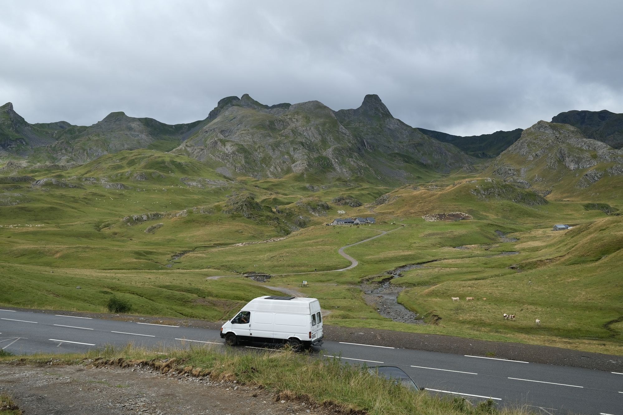 White panel van on an open road in hill country